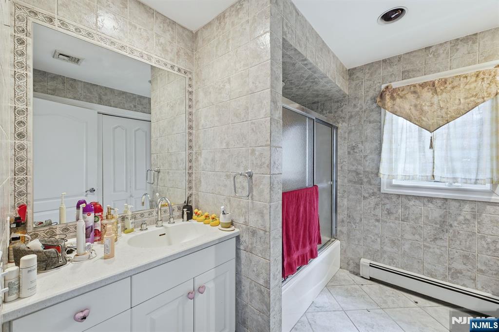 703 Stewart Street Ridgefield, NJ 07657 - Photo 29 of 38 a bathroom with a sink and a mirror