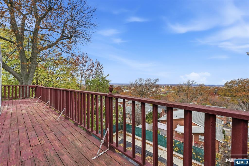 703 Stewart Street Ridgefield, NJ 07657 - Photo 32 of 38 a balcony with wooden floor and fence