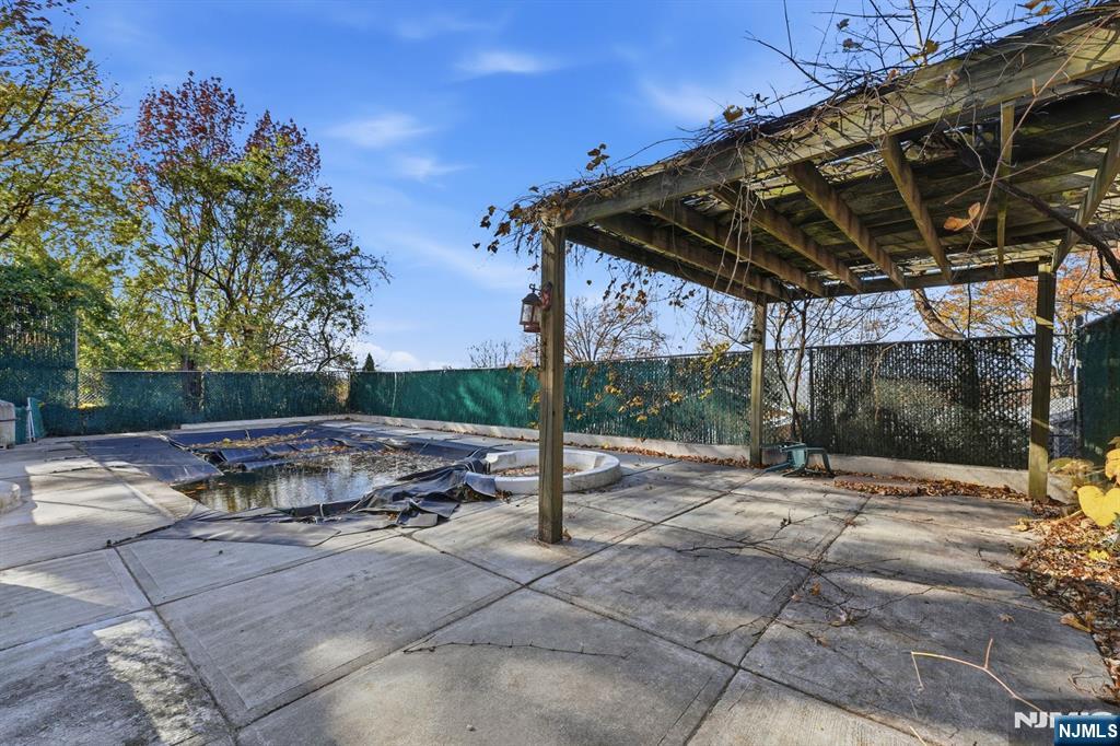 703 Stewart Street Ridgefield, NJ 07657 - Photo 33 of 38 a view of a patio with table and chairs with wooden floor and fence