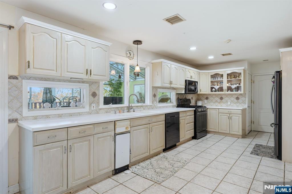 703 Stewart Street Ridgefield, NJ 07657 - Photo 6 of 38 a kitchen with a sink window and cabinets
