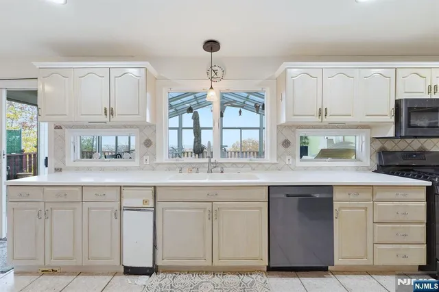 a kitchen with white cabinets and sink