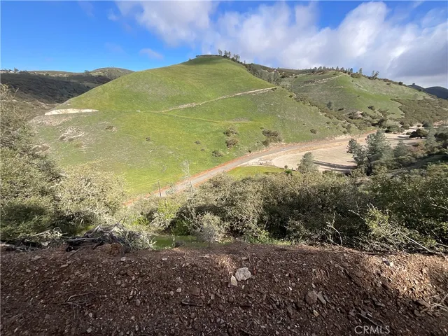a view of a dry yard with wooden fence