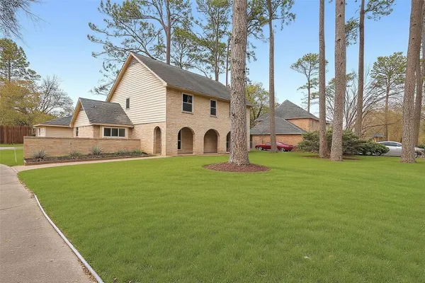 a view of a white house with a yard and sitting area