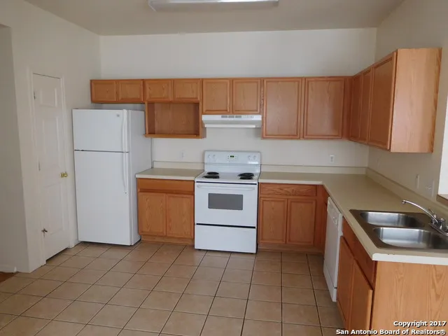 a kitchen with a stove top oven and cabinets