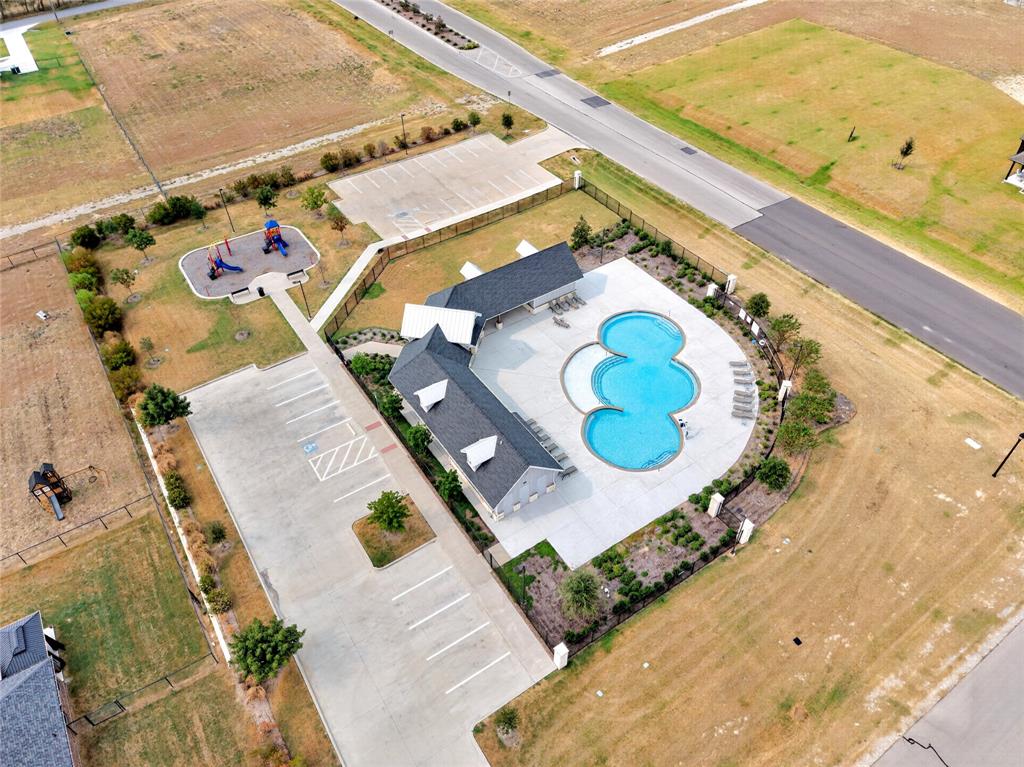 113 Ridgetop Trail Rhome, TX 76078 - Photo 32 of 32 Community swimming pool with surrounding lounge area, adjacent clubhouse building, separate playground area, and dedicated parking lot