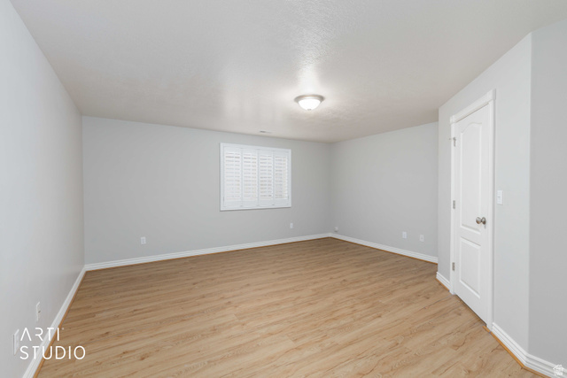 2327 Bluff Ridge Drive Syracuse, UT 84075 - Photo 34 of 66 Spacious room featuring wood-finish flooring, light grey walls, and white baseboards