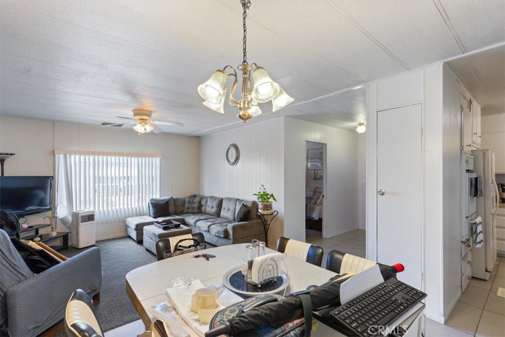 300 North Rampart Street, Unit 195 Orange, CA 92868 - Photo 7 of 25 a living room with dining table and a chandelier