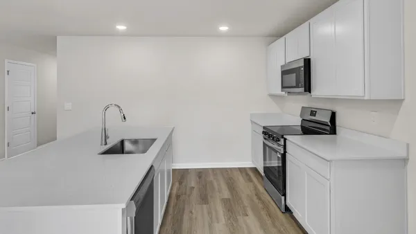 a kitchen with a sink a microwave and cabinets