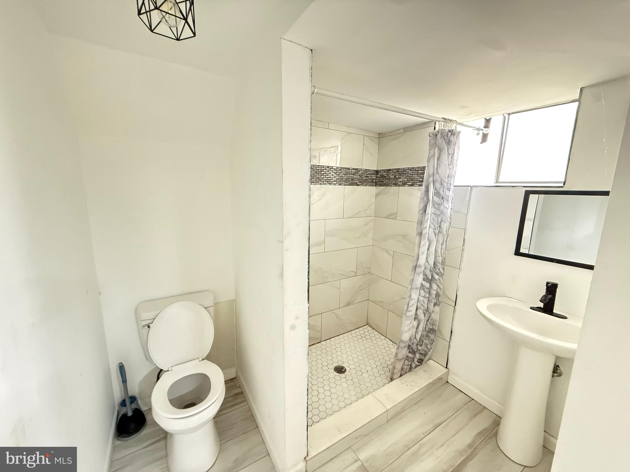 15205 Michigan Rd. Woodbridge, VA 22191 - Photo 14 of 20 a bathroom with a shower a toilet and sink