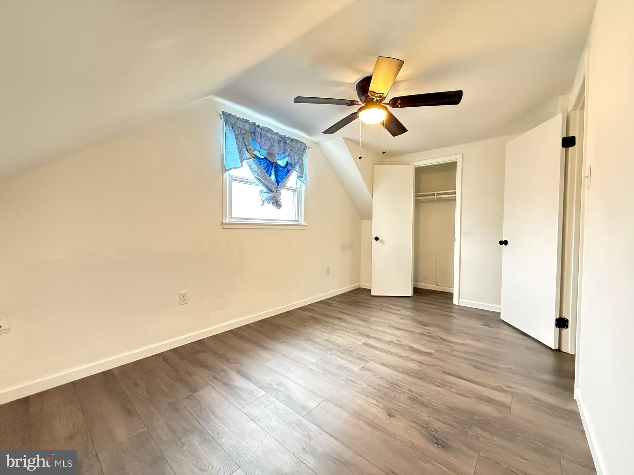 15205 Michigan Rd. Woodbridge, VA 22191 - Photo 7 of 20 an empty room with wooden floor ceiling fan and windows