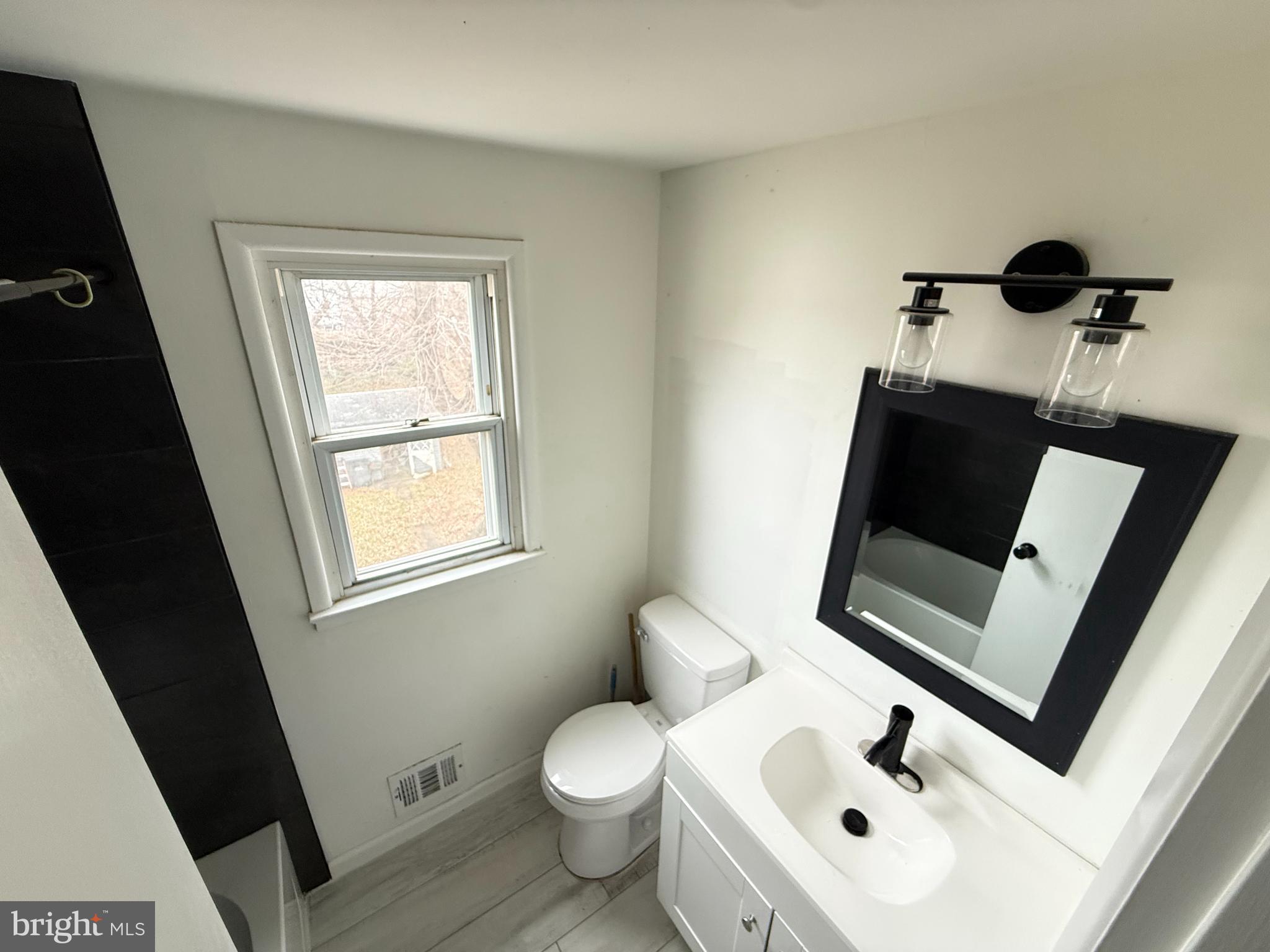 15205 Michigan Rd. Woodbridge, VA 22191 - Photo 8 of 20 a bathroom with a toilet sink and mirror