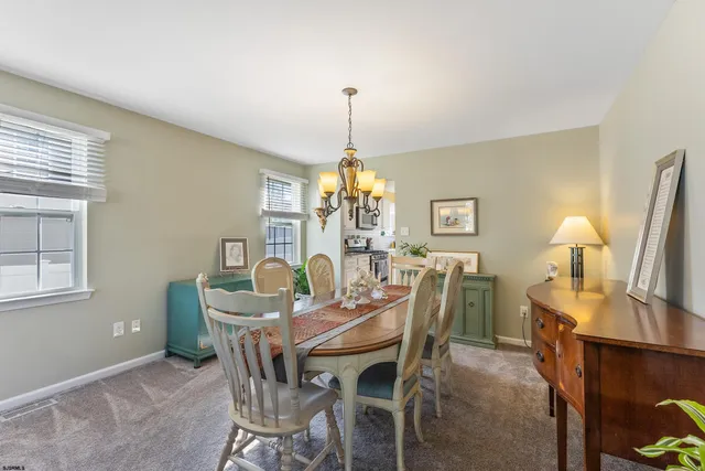 a dining room with furniture a chandelier and window