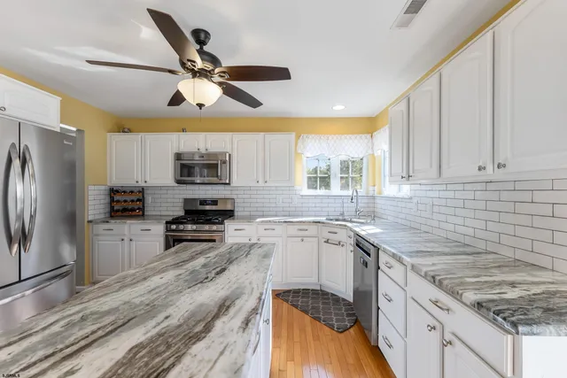 a kitchen with a sink appliances cabinets and a counter top space
