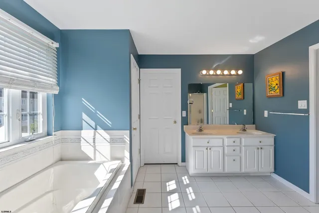 a bathroom with a tub sink and mirror