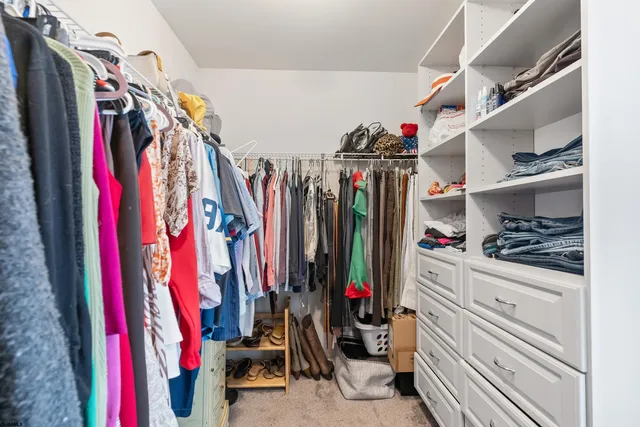 a view of walk in closet with clothes