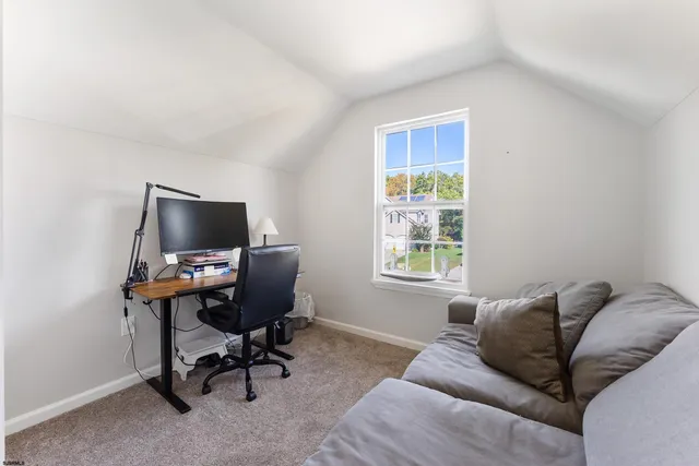 a livingroom with workspace couch and a window