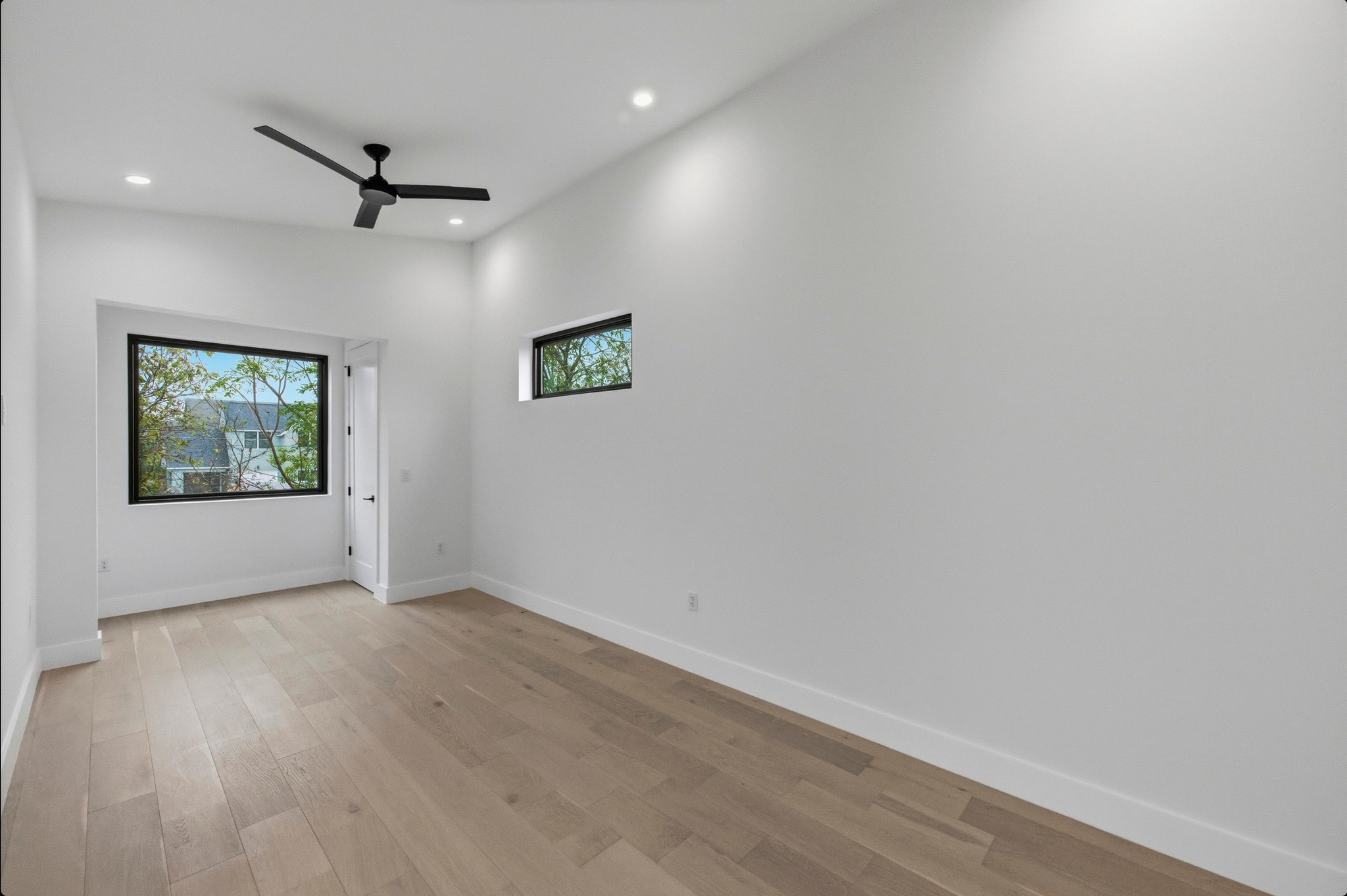 802 Philco Drive, Unit 2 Austin, TX 78745 - Photo 10 of 29 an empty room with wooden floor and windows
