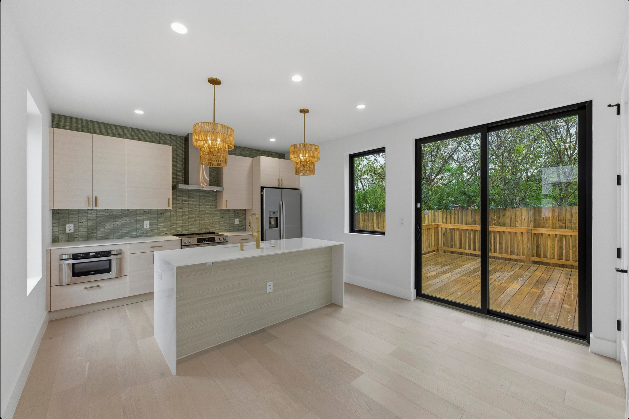 802 Philco Drive, Unit 2 Austin, TX 78745 - Photo 3 of 29 a large kitchen with stainless steel appliances kitchen island granite countertop a refrigerator a sink a stove and white cabinets with wooden floor