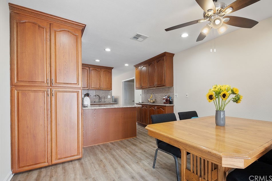1085 Driftwood Circle Placentia, CA 92870 - Photo 1 of 18 a kitchen with stainless steel appliances granite countertop a refrigerator a microwave oven a dining table and chairs with wooden floor