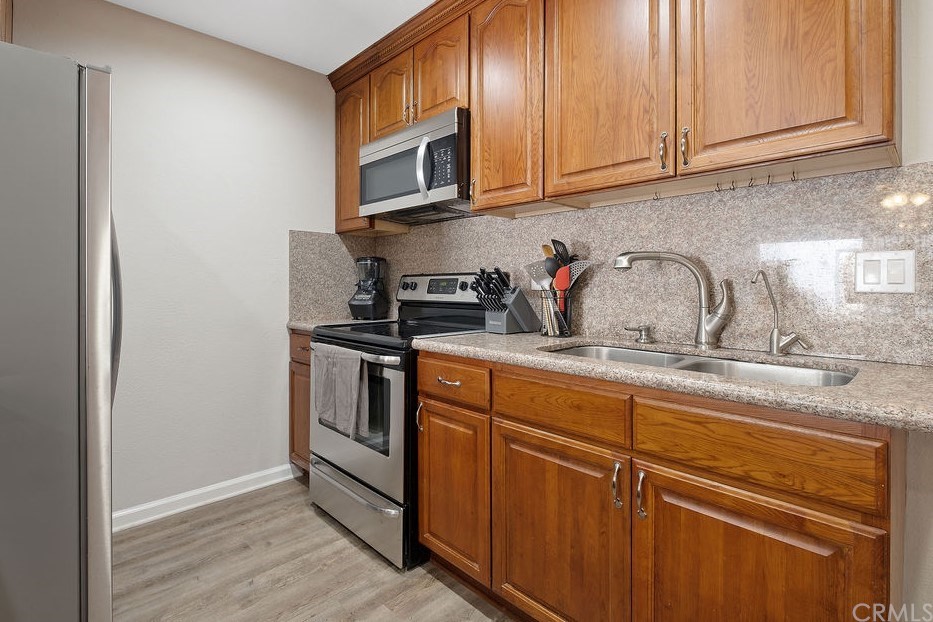 1085 Driftwood Circle Placentia, CA 92870 - Photo 4 of 18 a kitchen with stainless steel appliances granite countertop a sink and cabinets with wooden floor