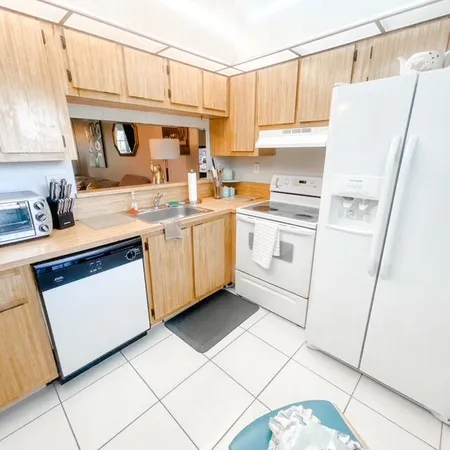 a kitchen with white cabinets sink and white appliances