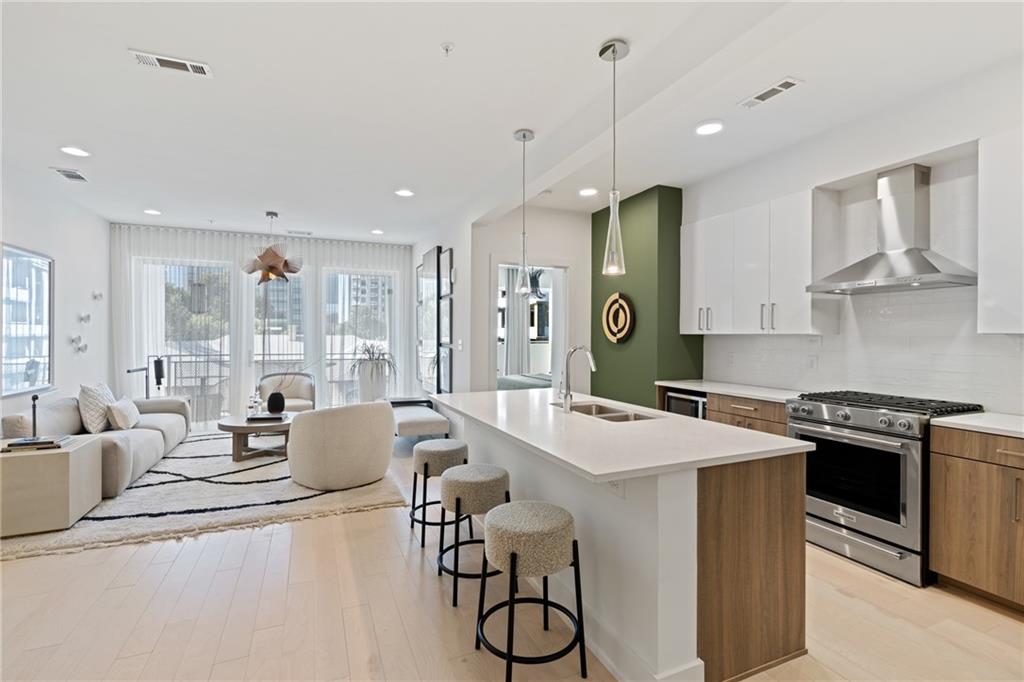 775 Juniper Street Northeast, Unit 227 Atlanta, GA 30308 - Photo 2 of 42 a large kitchen with stainless steel appliances a stove a sink dishwasher a dining table and chairs