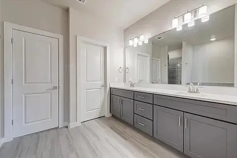 a bathroom with a double vanity sink and mirror
