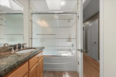 a bathroom with a granite countertop sink mirror and shower