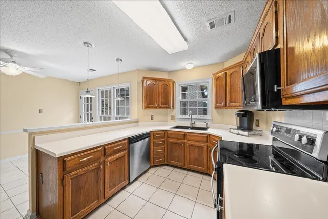 a kitchen with stainless steel appliances granite countertop a sink and dishwasher a stove top oven with wooden floor