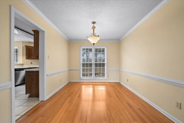a view of a room with wooden floor exposed radiator and windows