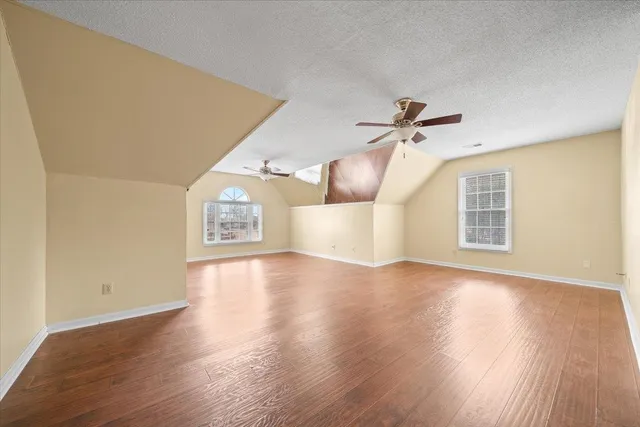 a view of a livingroom with wooden floor and a ceiling fan