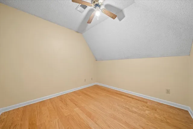 a view of a room with wooden floor and fan