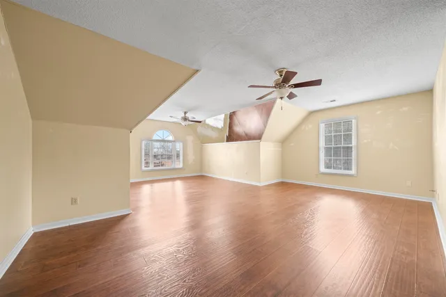 a view of a livingroom with wooden floor and a ceiling fan