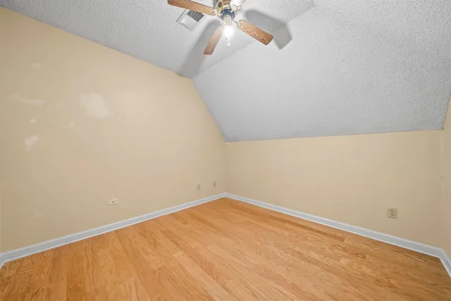 a view of a room with wooden floor and fan