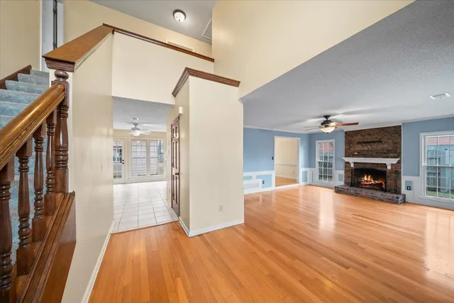 a view of empty room with fireplace and wooden floor