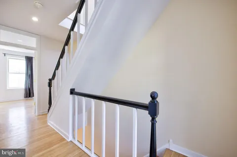 a view of a hallway with wooden floor and staircase
