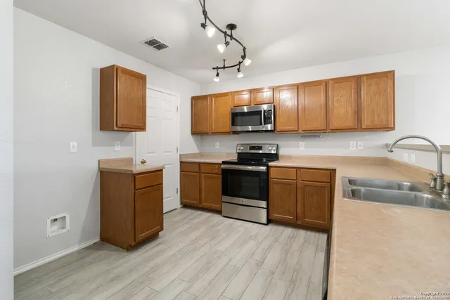 a kitchen with kitchen island granite countertop a sink appliances cabinets and a counter top space