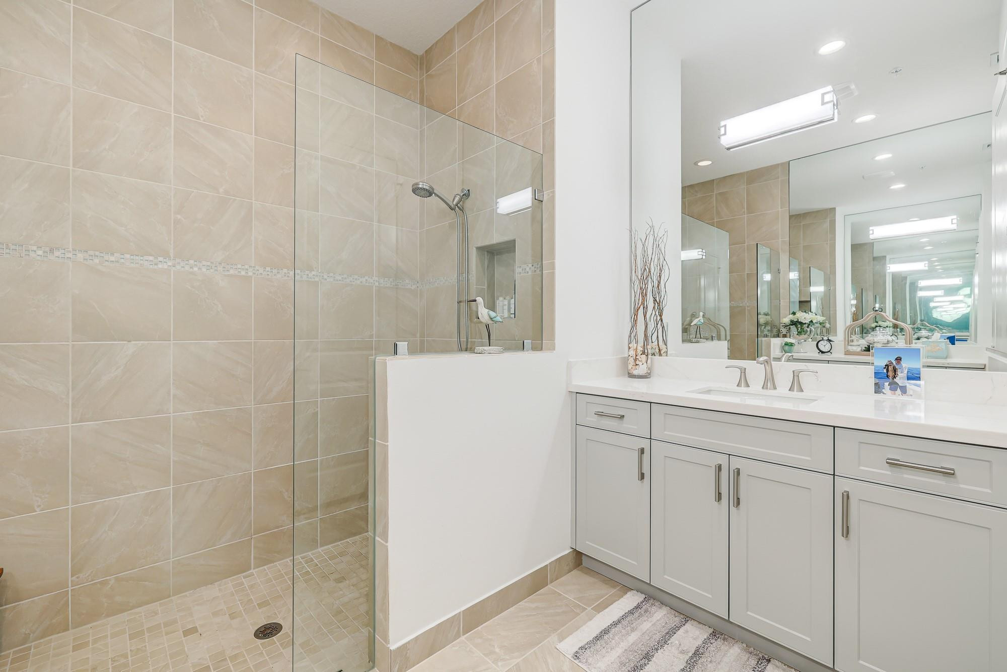 22954 Clear Echo Drive, Unit 31 Boca Raton, FL 33433 - Photo 20 of 38 a bathroom with a shower sink and mirror