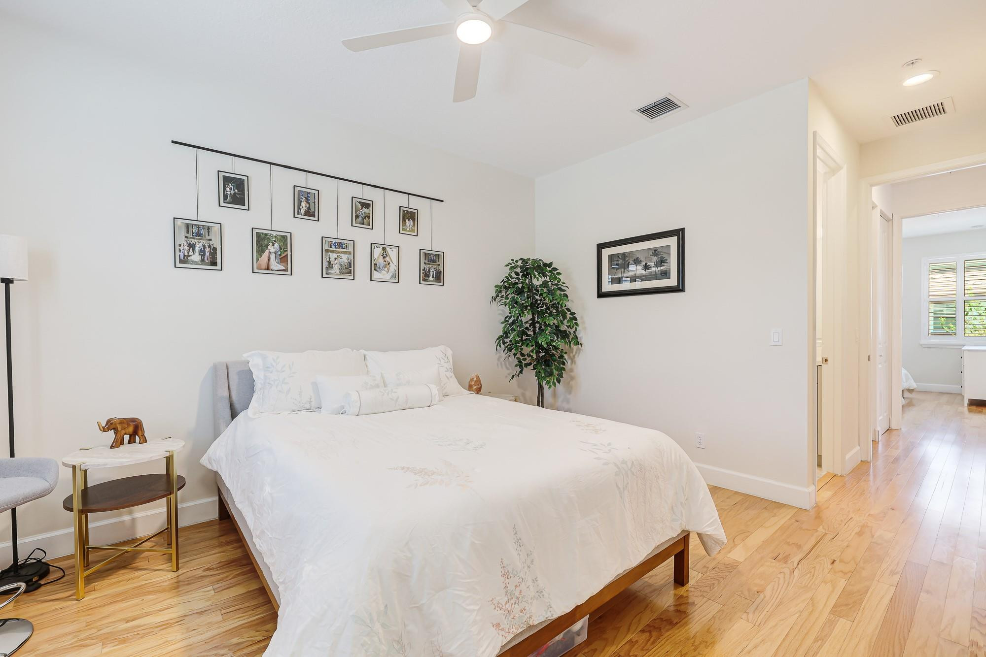 22954 Clear Echo Drive, Unit 31 Boca Raton, FL 33433 - Photo 32 of 38 a bedroom with a large bed and a chandelier