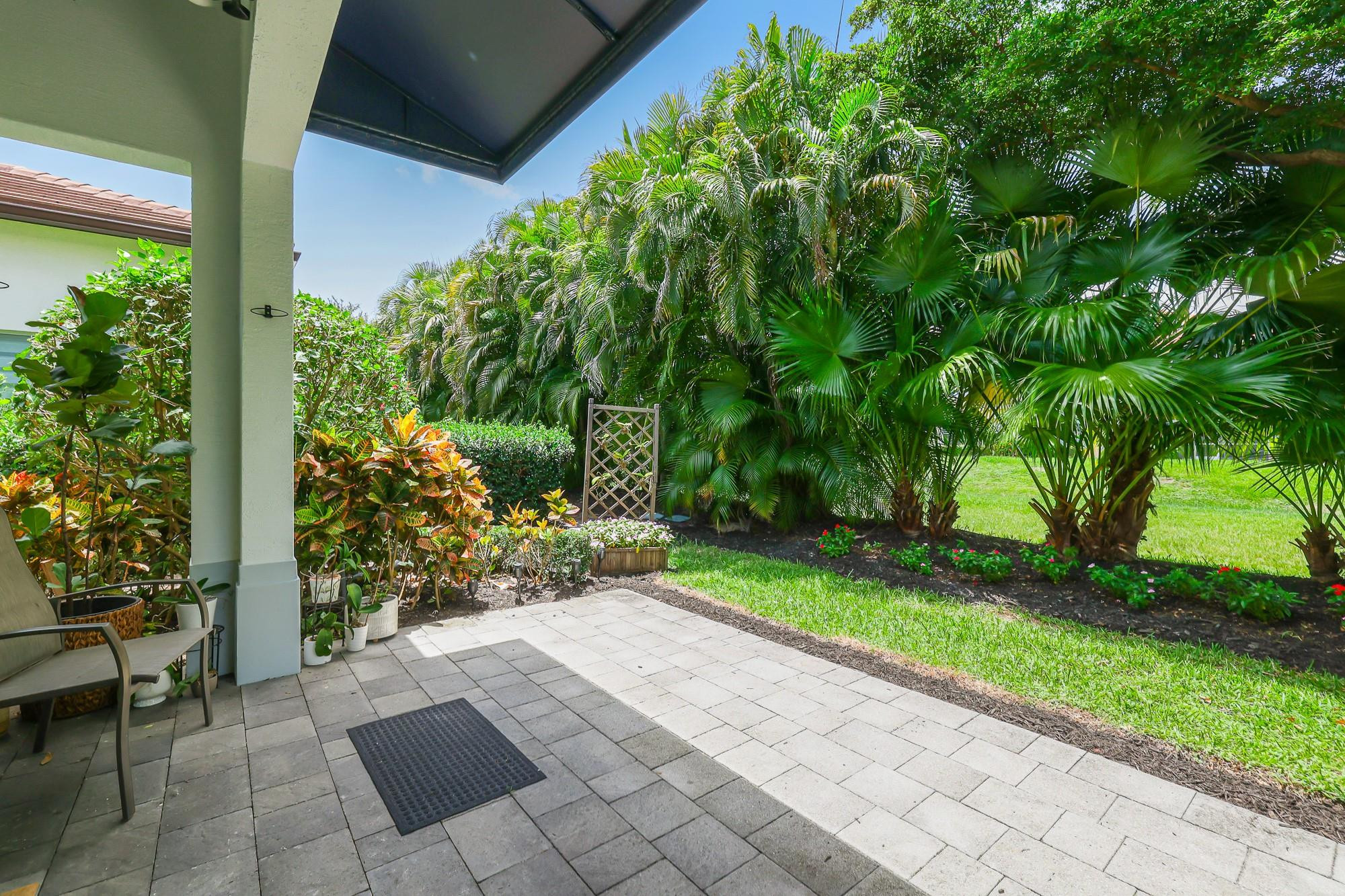 22954 Clear Echo Drive, Unit 31 Boca Raton, FL 33433 - Photo 35 of 38 a view of a backyard with potted plants and a large tree