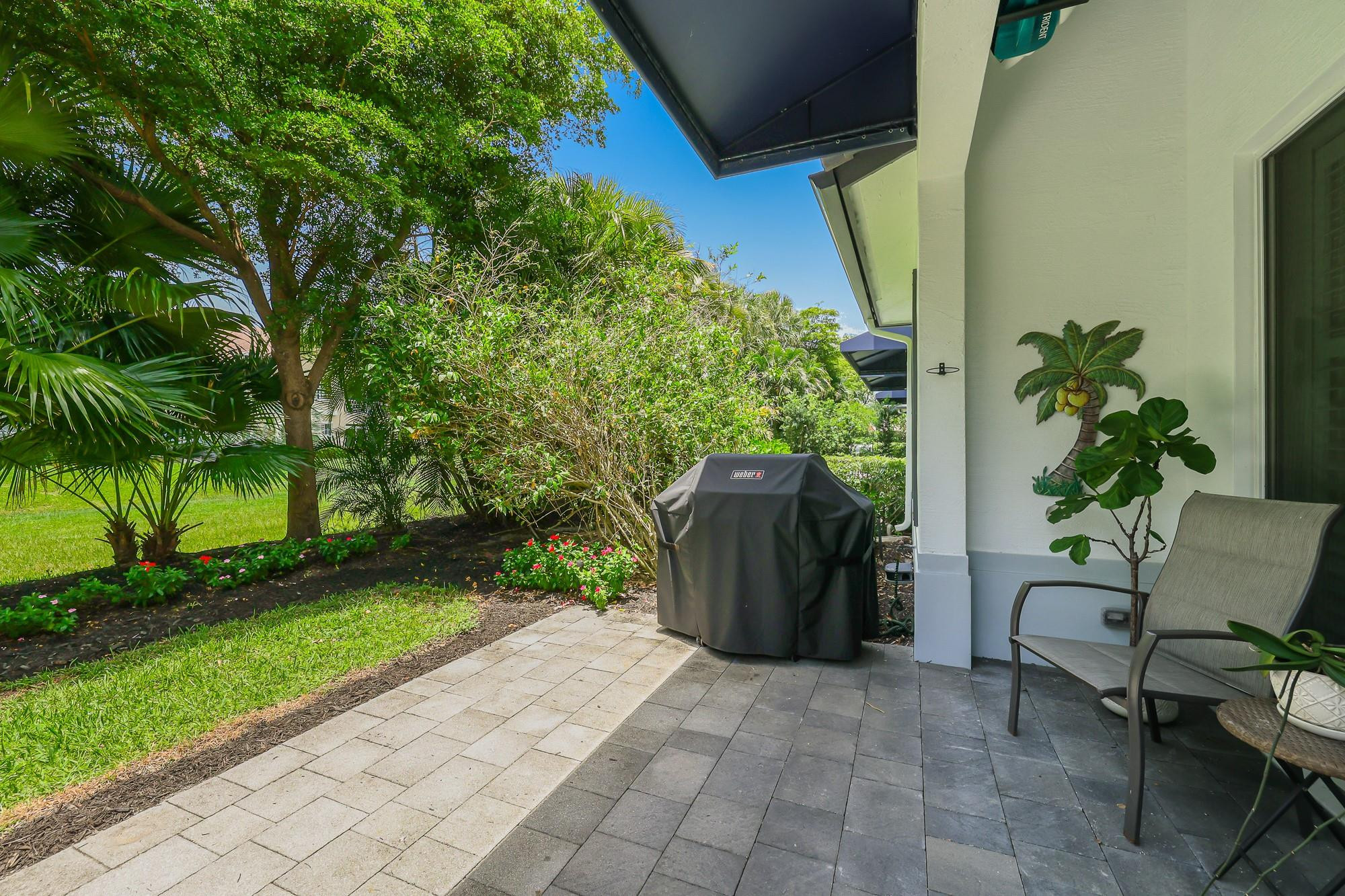 22954 Clear Echo Drive, Unit 31 Boca Raton, FL 33433 - Photo 36 of 38 a view of a garden with a chair and potted plants