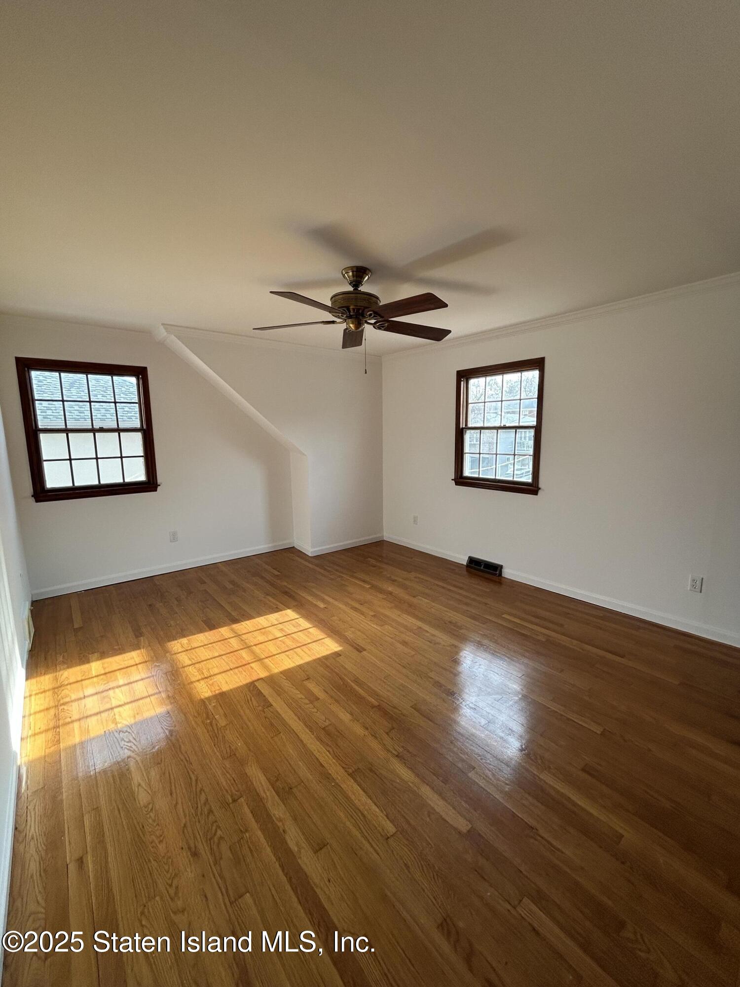 173 Rome Avenue Staten Island, NY 10304 - Photo 10 of 27 a view of empty room with wooden floor and fan