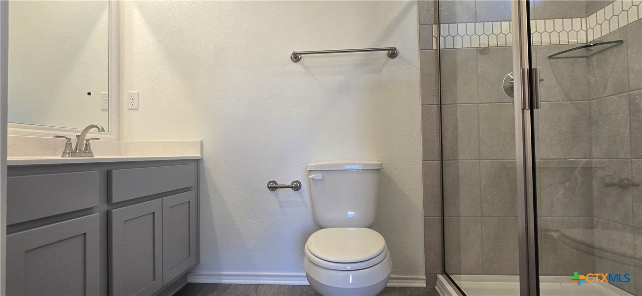 334 Monty Road Copperas Cove, TX 76522 - Photo 16 of 17 a bathroom with a granite countertop sink toilet and shower