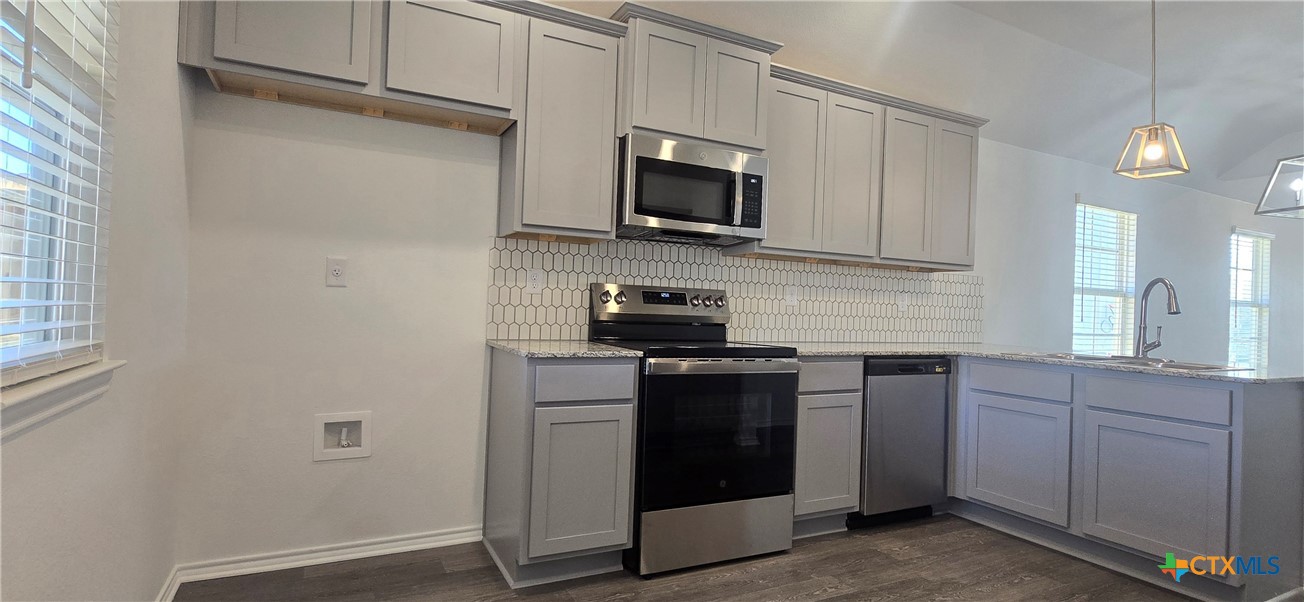334 Monty Road Copperas Cove, TX 76522 - Photo 8 of 17 a kitchen with stainless steel appliances granite countertop a stove a sink and a microwave