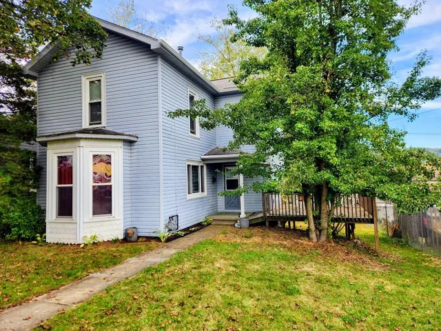 a view of a house with backyard and sitting area
