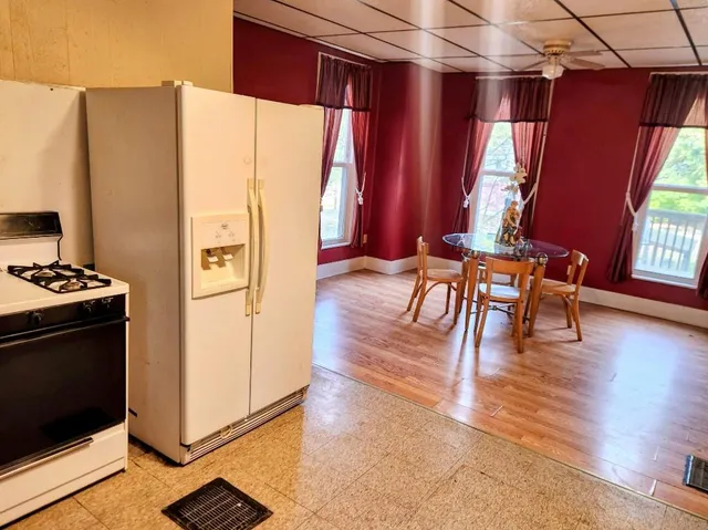 a view of dining room with wooden floor and windows