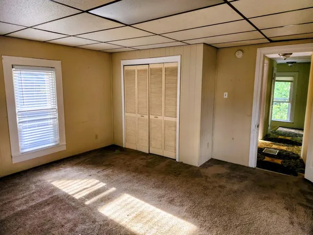 a view of empty room with wooden floor and window