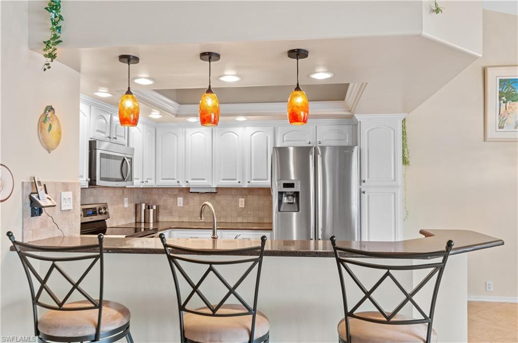 a kitchen with stainless steel appliances a stove a sink cabinets and dining table