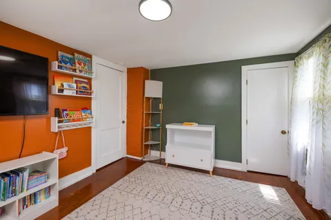 a view of an empty room with closet and a window