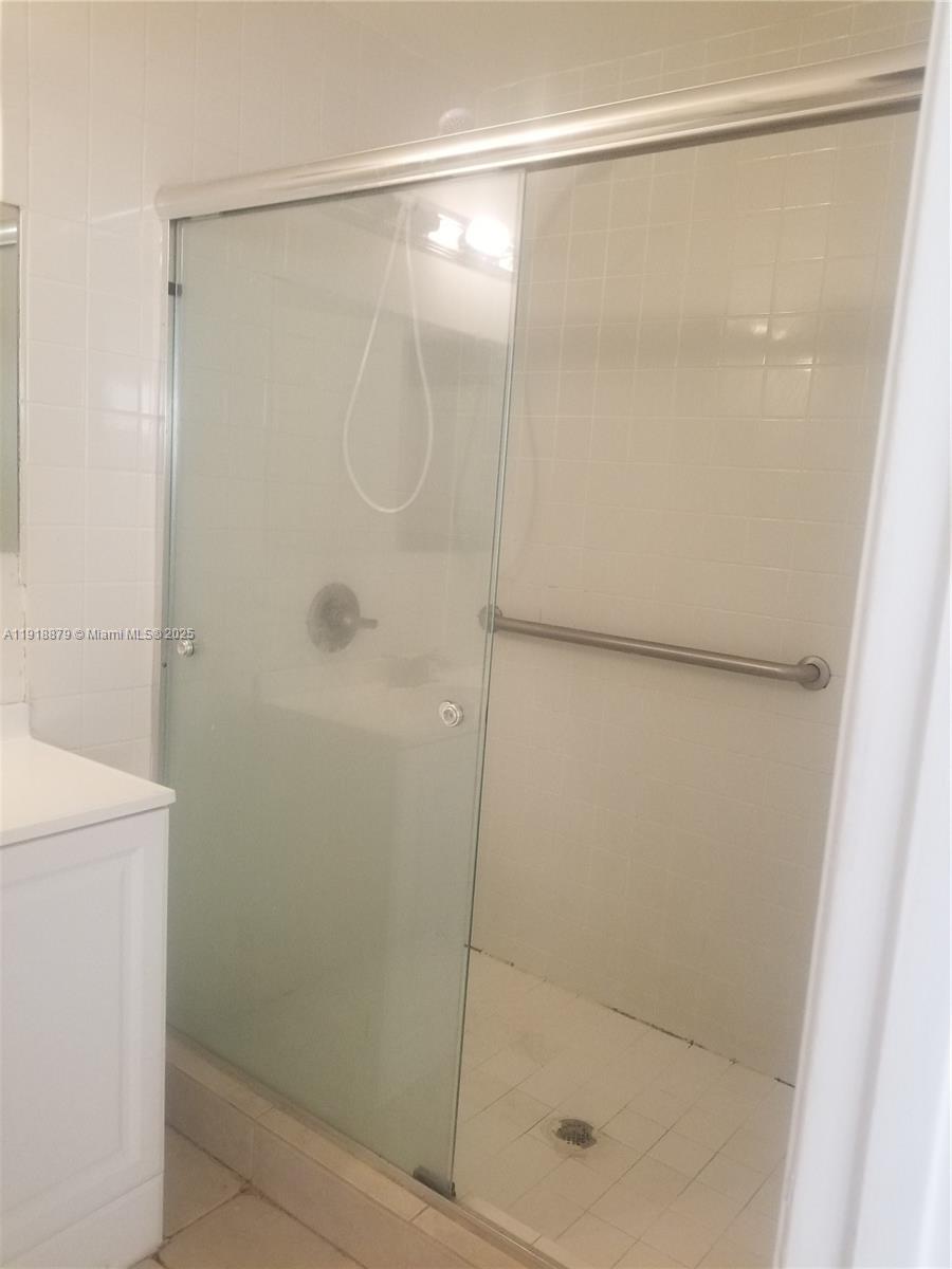15 Crossings Circle, Unit A Boynton Beach, FL 33435 - Photo 8 of 14 a bathroom with a glass shower door